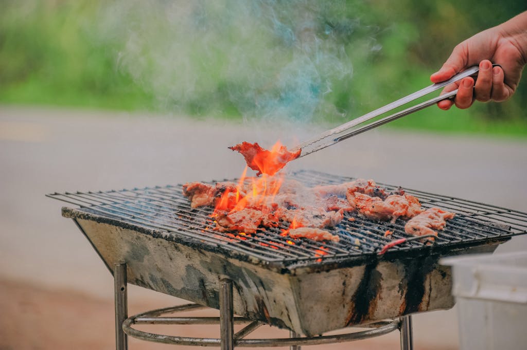 Person Holding Tongs Ccoking Barbecue