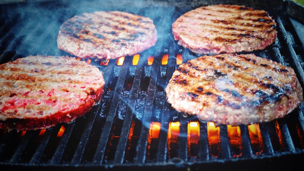 Shallow Focus Photo of Patties on Grill